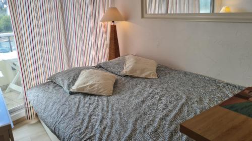 une chambre avec un lit avec deux oreillers dessus dans l'établissement Studio Judith - Dinard Plage, à Dinard