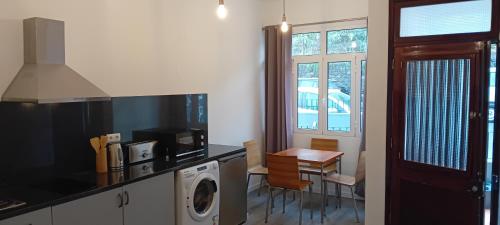 a kitchen with a washer and dryer and a table at Vista Funchal in Funchal