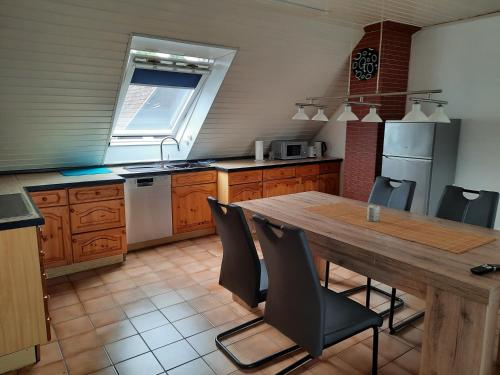 a kitchen with a wooden table and chairs in it at Ferienwohnung Elena 2 in Zweibrücken