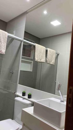 a bathroom with a sink and a toilet and a mirror at Casa moderna e confortável 2andar in Leopoldina
