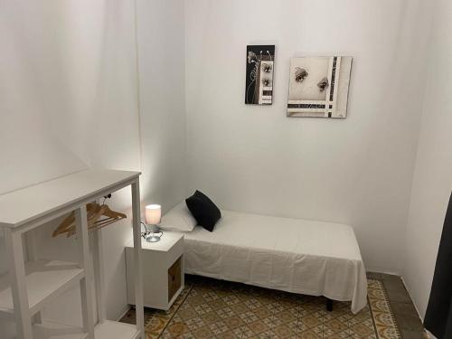 Habitación pequeña con cama y escritorio. en Des Artistes, en Barcelona