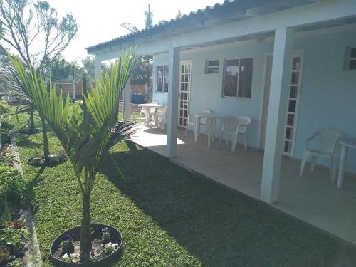 a house with a palm tree in the yard at QUARTO COM COZINHA E CHURASQUEIRA INDIVIDUAL. in Passo de Torres