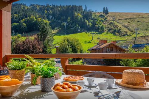 - une table avec de la nourriture et une vue sur la montagne dans l'établissement Le Grand Bossonnet - OVO Network, à La Clusaz