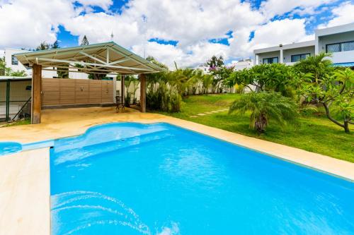a large blue swimming pool in front of a house at Stella Marris beachfront villa in Pointe aux Sable