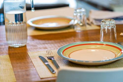 a wooden table with a plate and a fork and knife at Stella Marris beachfront villa in Pointe aux Sable