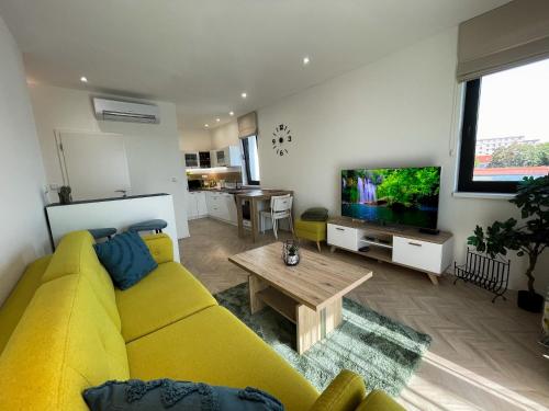 a living room with a yellow couch and a tv at Luxury City Retreat with Terrace in Košice