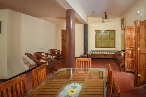 a living room with a glass table and chairs at Villa in the woods in Trichūr