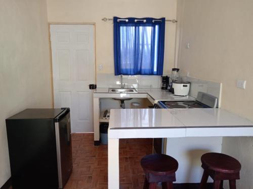eine Küche mit einem Waschbecken und einer Theke mit zwei Stühlen in der Unterkunft Villas El Alto 4 in Cóbano