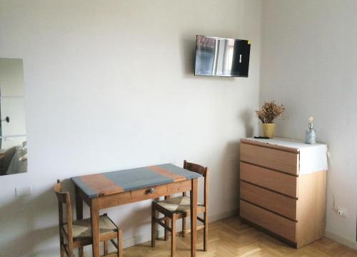 Stanze Ildesco في بيرغامو: طاولة غرفة طعام مع كراسي وخزانة في الغرفة