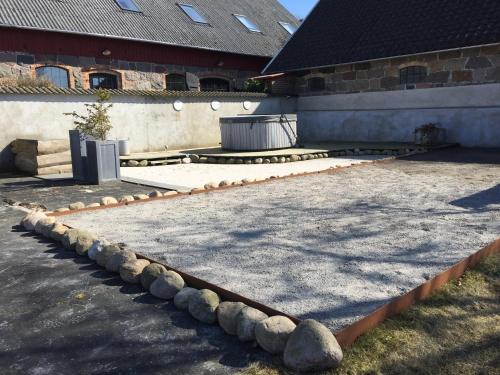 a patio with rocks on the ground in front of a building at Lyckås Gårds Gästboende in Höganäs