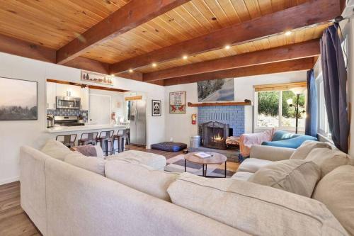 a living room with a large couch and a fireplace at Ursa Minor- Modern Resort Chalet- Hot Tub in Big Bear Lake