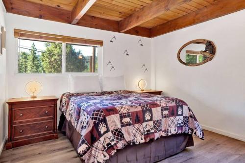 a bedroom with a bed and a window at Ursa Minor- Modern Resort Chalet- Hot Tub in Big Bear Lake