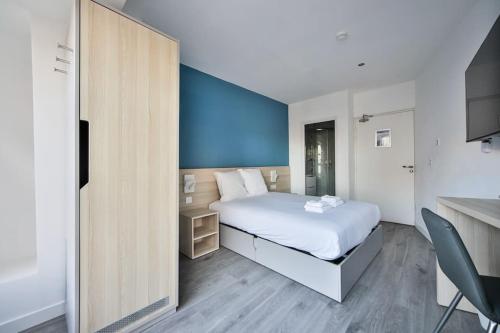 a bedroom with a white bed and a blue wall at 11.Studio#Charenton#Fitness#Cinema in Charenton-le-Pont