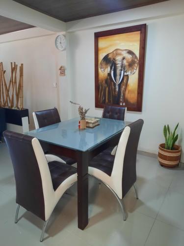 een eettafel met stoelen en een schilderij van een olifant bij Casa central, segundo piso con parqueadero in Norcasia