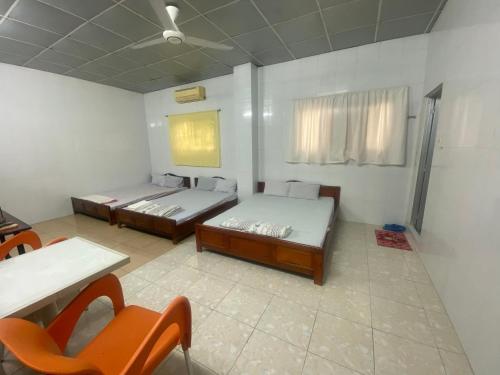 Zimmer mit 2 Betten, einem Tisch und Stühlen in der Unterkunft NHÀ NGHỈ LÊ TUẤN 