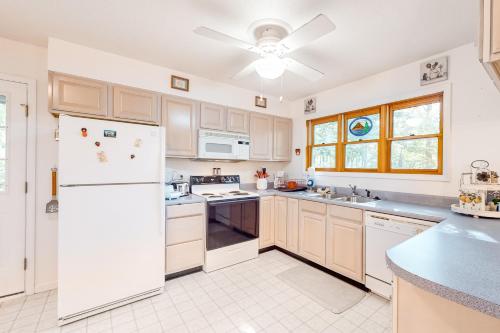 a kitchen with white appliances and a ceiling fan at Sandy Beech in Beech Mountain