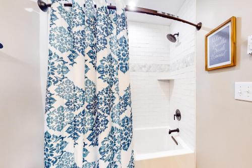 a bathroom with a blue and white shower curtain at Sandy Beech in Beech Mountain