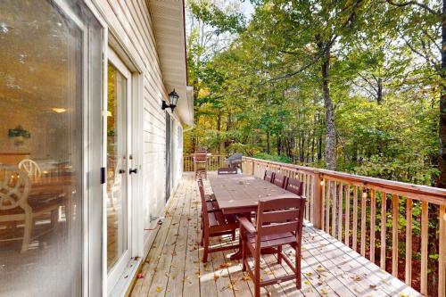 a wooden deck with a table and chairs on it at Sandy Beech in Beech Mountain