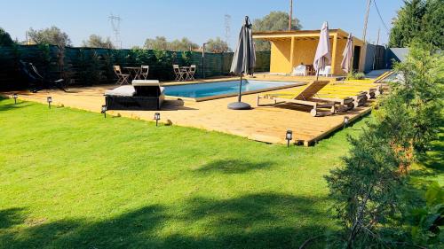 a backyard with a swimming pool and a lawn at Chalé do Vale in Pinhal Novo