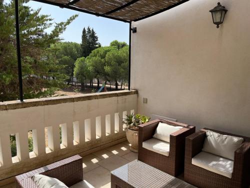 eine Terrasse mit 2 Stühlen und einem Tisch auf dem Balkon in der Unterkunft Masseria La Camardia in Sava