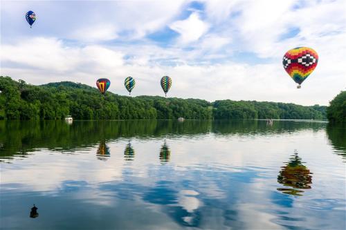 a group of hot air balloons floating over a lake at The Golf View, boutique Galena getaway! in Galena