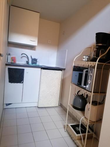 une petite cuisine avec un évier et une cuisinière dans l'établissement Superbe studio proche de toutes commodités, à Franqueville-Saint-Pierre