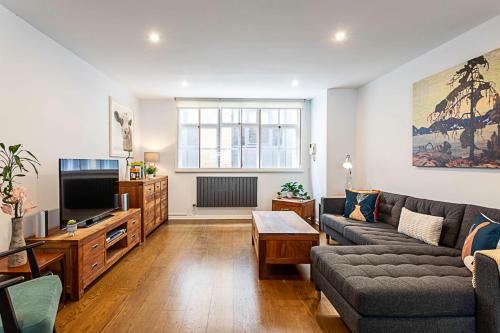 a living room with a couch and a tv at Blackfriars Printhouse Retreat in London