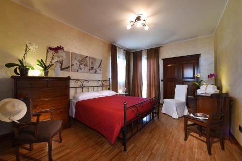 a bedroom with a red bed and a desk and chairs at Villa Vecchio in Castagnito