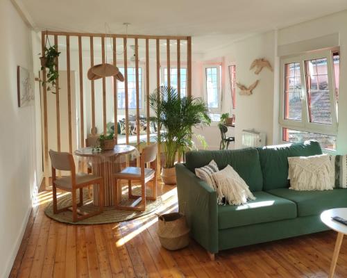 a living room with a green couch and a table at Apartamento con encanto en el puerto de Bermeo in Bermeo