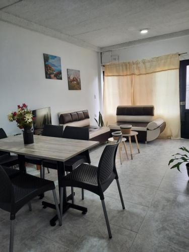 ein Wohnzimmer mit einem Tisch, Stühlen und einem Sofa in der Unterkunft Casa Central, primer piso in Norcasia