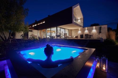 a woman sitting in a swimming pool at night at Ławka i Sielawka - dom nad jeziorem z prywatnym pomostem in Tomaszkowo