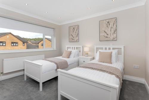 2 camas en una habitación blanca con ventana en Air Host and Stay - Formby station sanctuary sleeps 9, parking, 2 bath en Formby