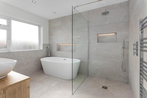 a bathroom with a tub and a glass shower at Air Host and Stay - Formby station sanctuary sleeps 9, parking, 2 bath in Formby