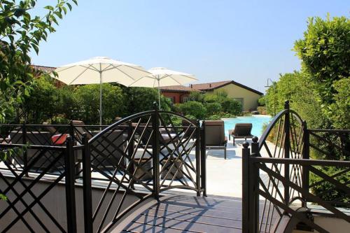 a patio with chairs and an umbrella and a pool at Joia Hotel & Luxury Apartments RTA in Brusaporto