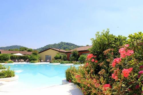 a swimming pool in a yard with flowers at Joia Hotel & Luxury Apartments RTA in Brusaporto