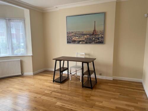 una habitación con una mesa y una foto de la torre Eiffel en Vyner House en Londres