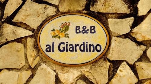 a sign that says abba a grandgio on a stone wall at B&B Al Giardino in Monreale