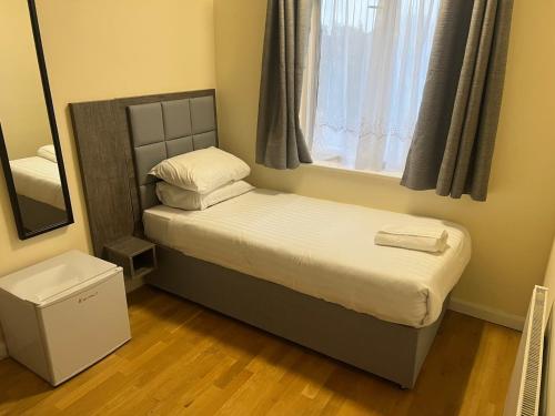 Dormitorio pequeño con cama y espejo en Vyner House en Londres