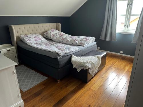 a small bed in a room with a wooden floor at Stor villa sentralt på Leknes in Leknes