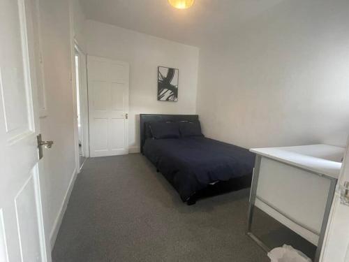 a small bedroom with a bed and a sink at 3 Bedroom House in Dartford in Kent