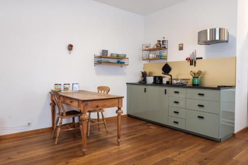 a kitchen with a wooden table and a desk at Zaunkönig Apartments in Baden-Baden