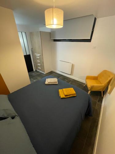 a room with a bed and a yellow chair at Gare australe in Saint-Brieuc