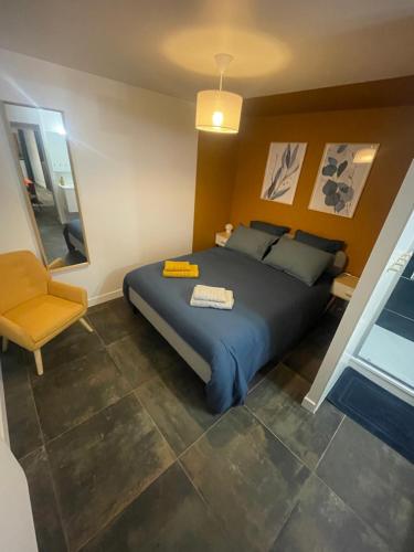 a bedroom with a large bed and a chair at Gare australe in Saint-Brieuc