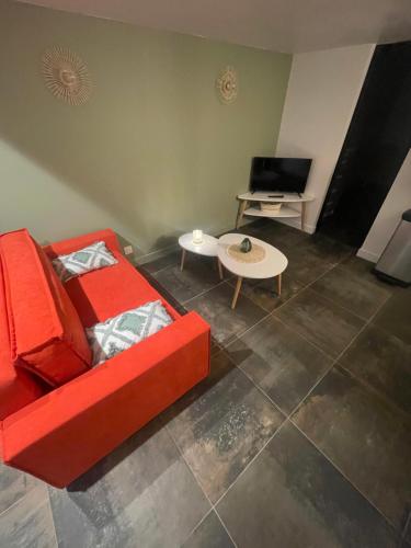 - un salon avec un canapé rouge et une table dans l'établissement Gare australe, à Saint-Brieuc