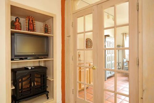 a living room with a tv and a door at Casa Cuma Bed & Breakfast in Santa Fe