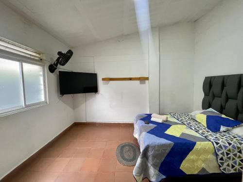 a bedroom with a bed and a flat screen tv at OUR HOME SAN ANTONIO in Cali