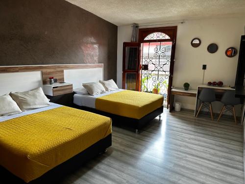 a bedroom with two beds and a stained glass window at Casa Marin Framboyan in Oaxaca City