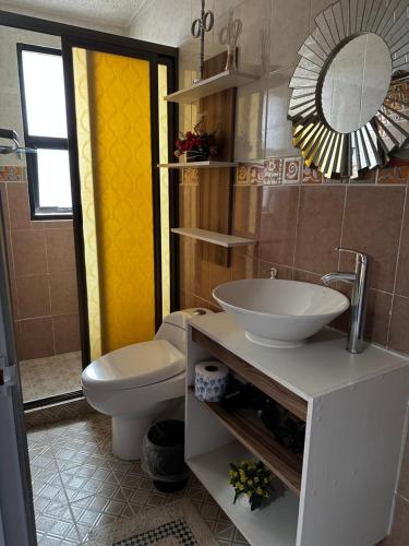 W łazience znajduje się umywalka, toaleta i lustro. w obiekcie Casa Marin Framboyan w mieście Oaxaca