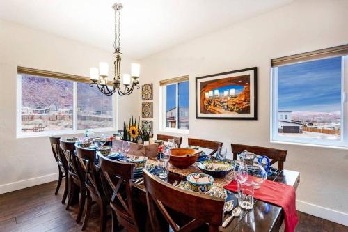a dining room with a table and chairs and windows at Gorgeous Moab Retreat in Moab