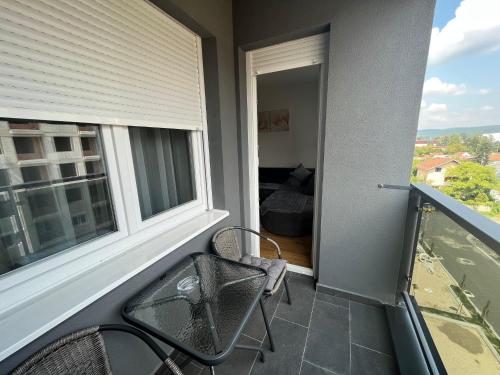 1 dormitorio y balcón con mesa y sillas. en Lady en Banja Luka